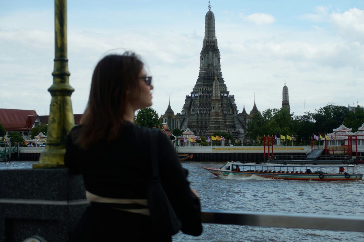 Woman is taking a photo with Wat Arun